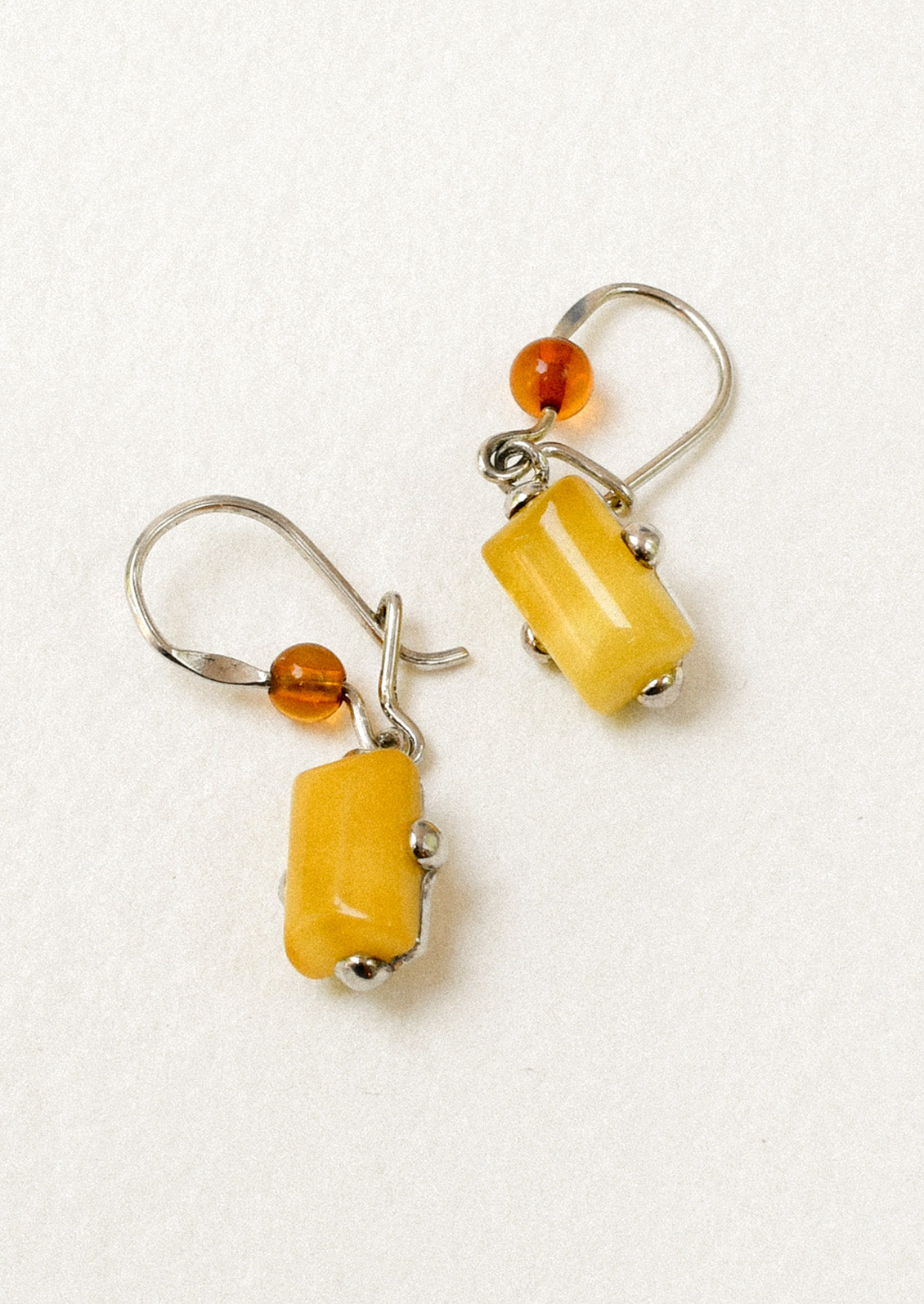 A pair of sterling silver earrings adorned with a round carnelian and a marigold stone.