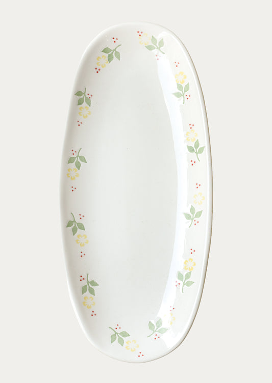 A long oval ceramic planter with yellow marigolds around the edge.