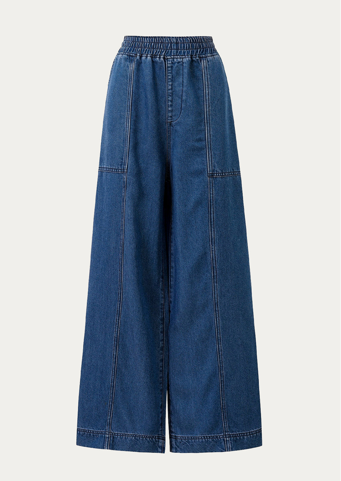 A person wearing a pair of relaxed denim pants with elasticized waistband.