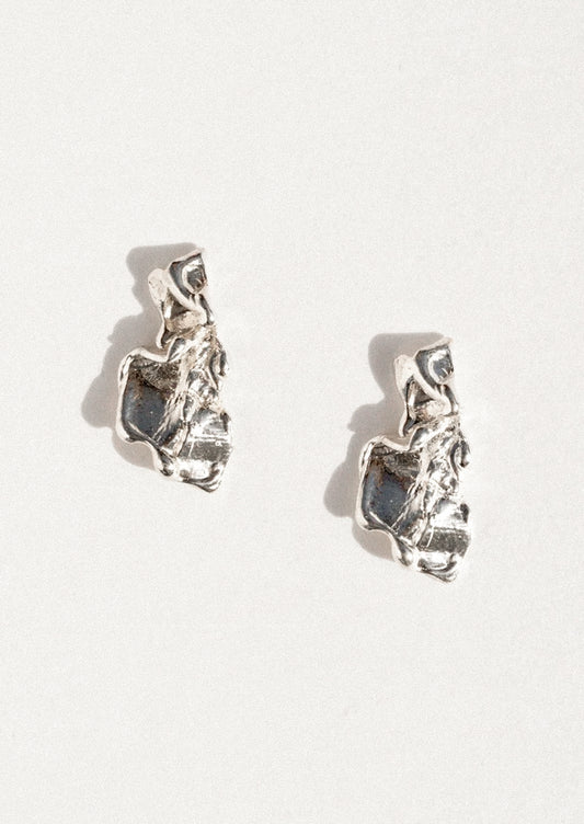 A pair of textured sterling silver earrings with organic, irregular shapes, displayed on a clean white background with soft shadows.