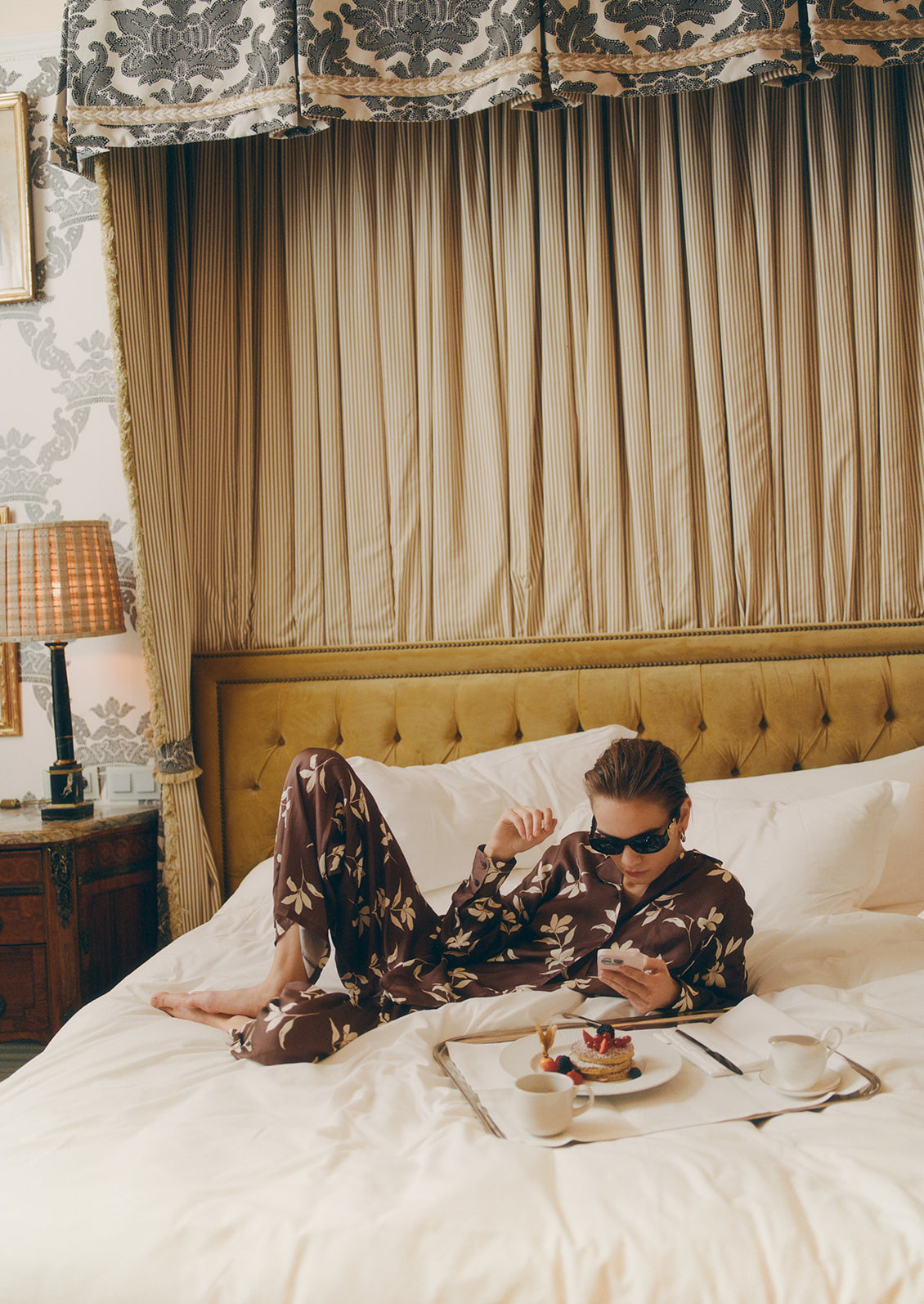 A person wearing a matching set of brown and white floral pajama style clothes.