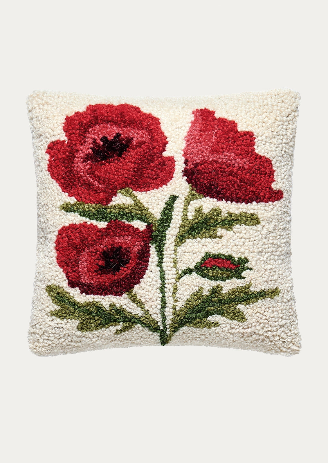 A square white bouclé throw pillow featuring a hand-tufted design of three red poppies with green stems and leaves, shown against a light gray background.