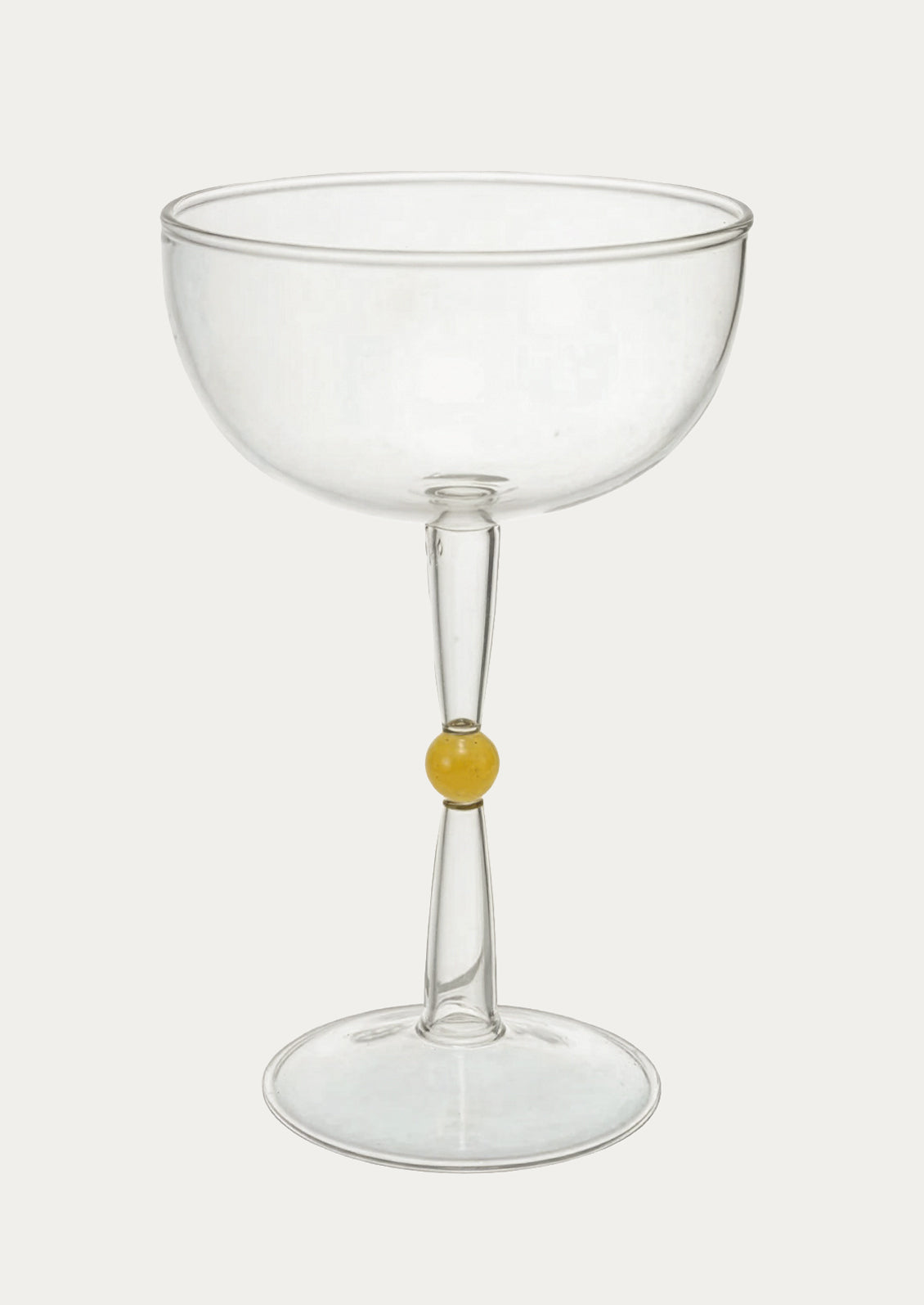 Clear glass coupe with a small yellow detail on a white background
