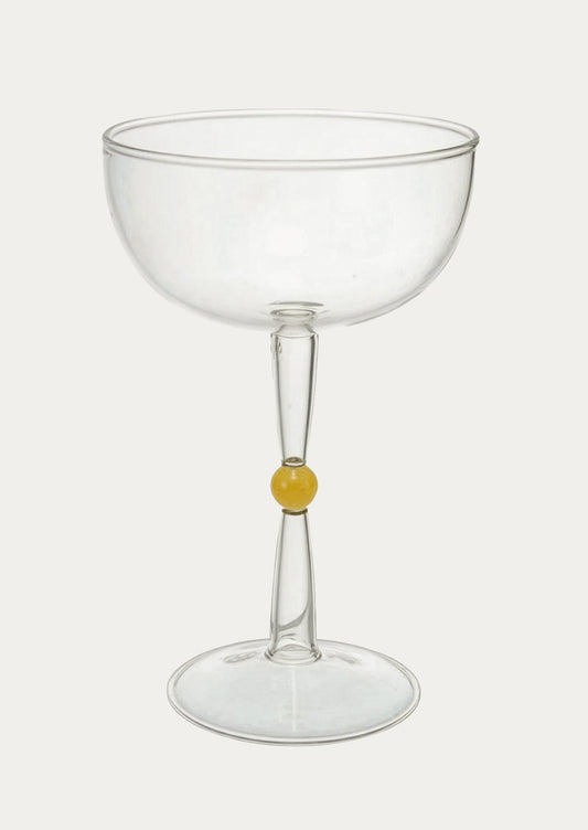 Clear glass coupe with a small yellow detail on a white background