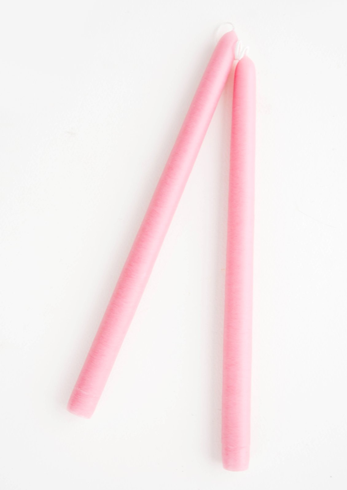A pair of taper candles in tulip pink.
