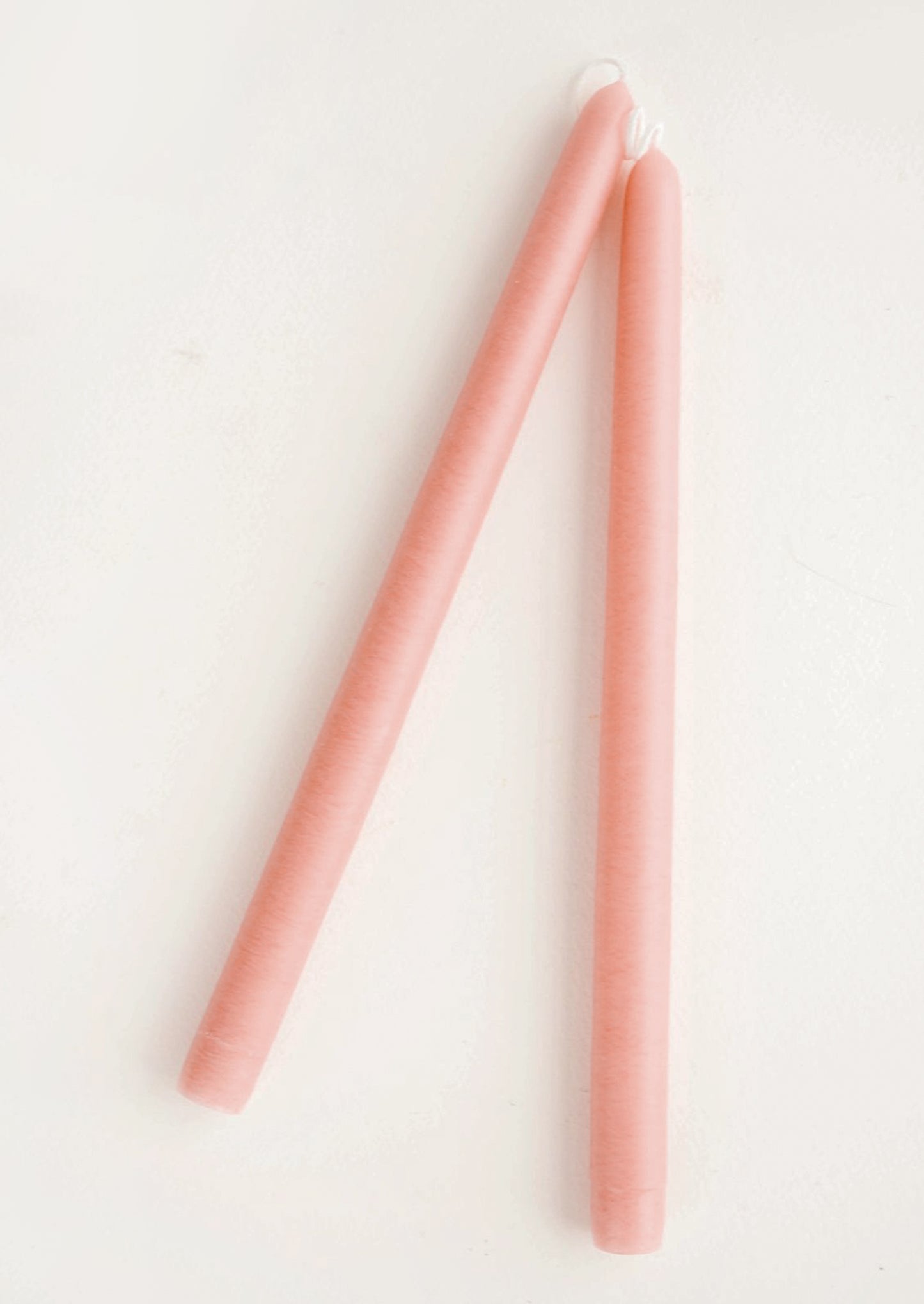 Two pink candles on a white background