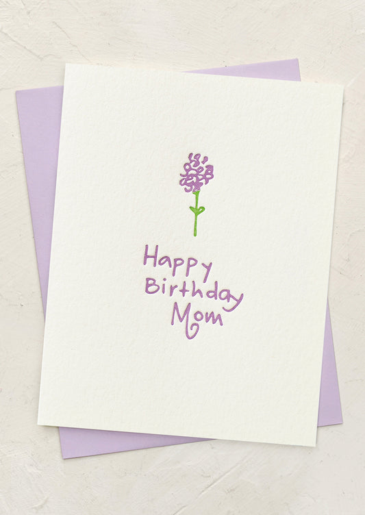Greeting card with a purple flower illustration and 'Happy Birthday Mom' text on a white background.