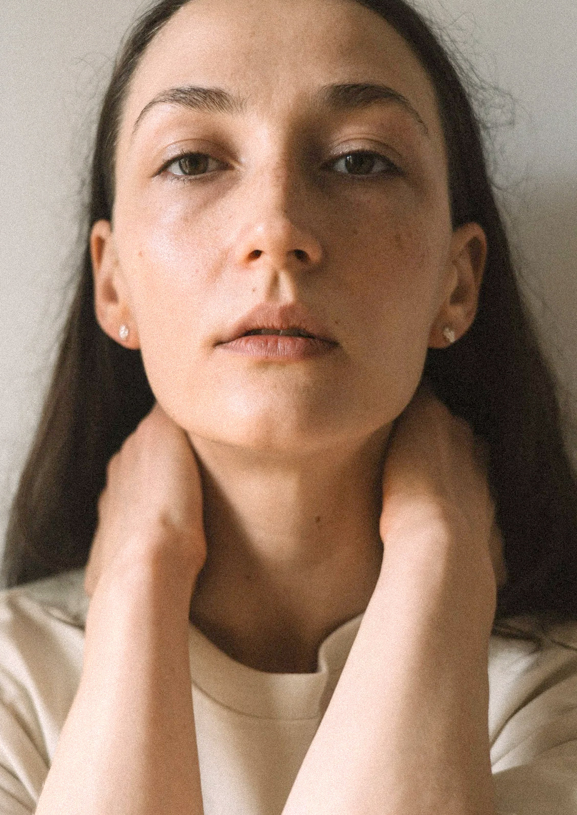 A woman wearing a pair of sterling silver stud earrings in an abstract shape.