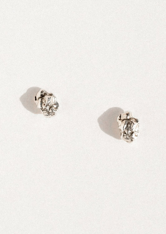 A pair of sterling silver stud earrings in an abstract shape.