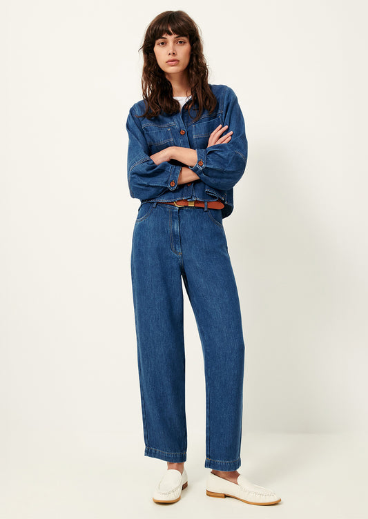 A woman wearing a denim jacket and pants in rich blue denim.