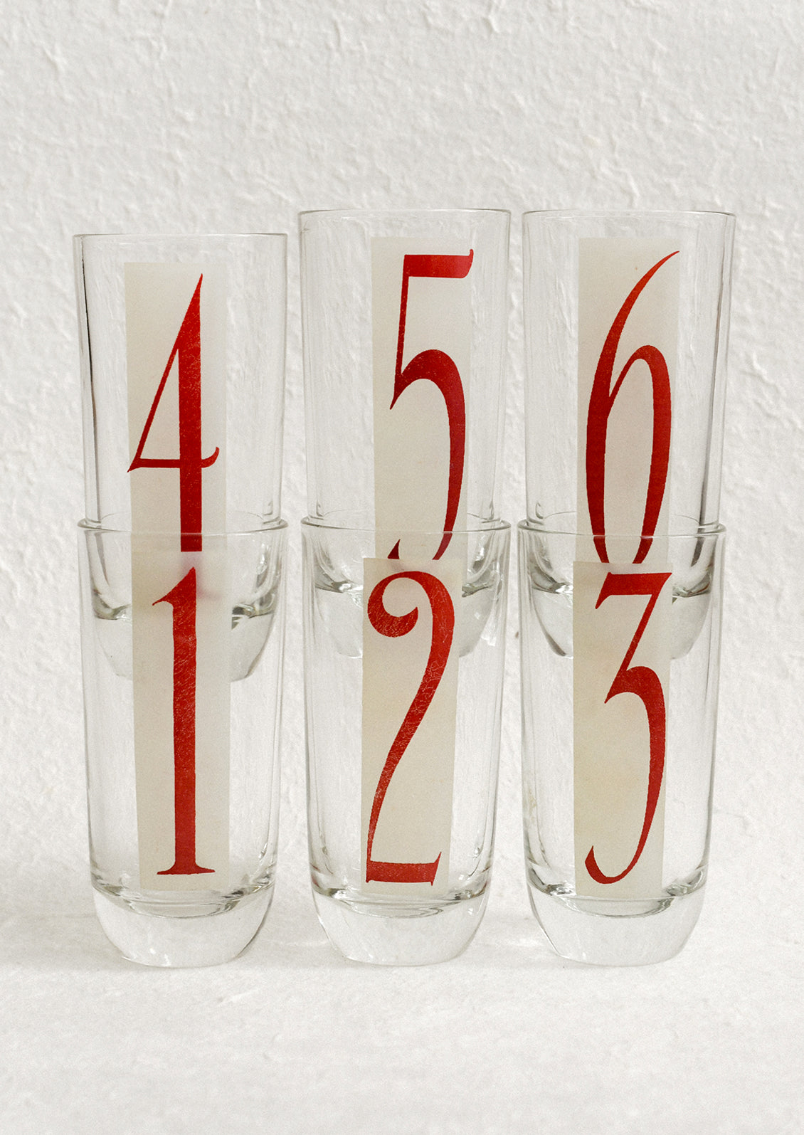 A set of high ball glasses with frosted red and white digit decal on each glass, numbering 1 through 6.
