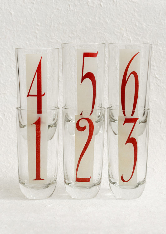 A set of high ball glasses with frosted red and white digit decal on each glass, numbering 1 through 6.