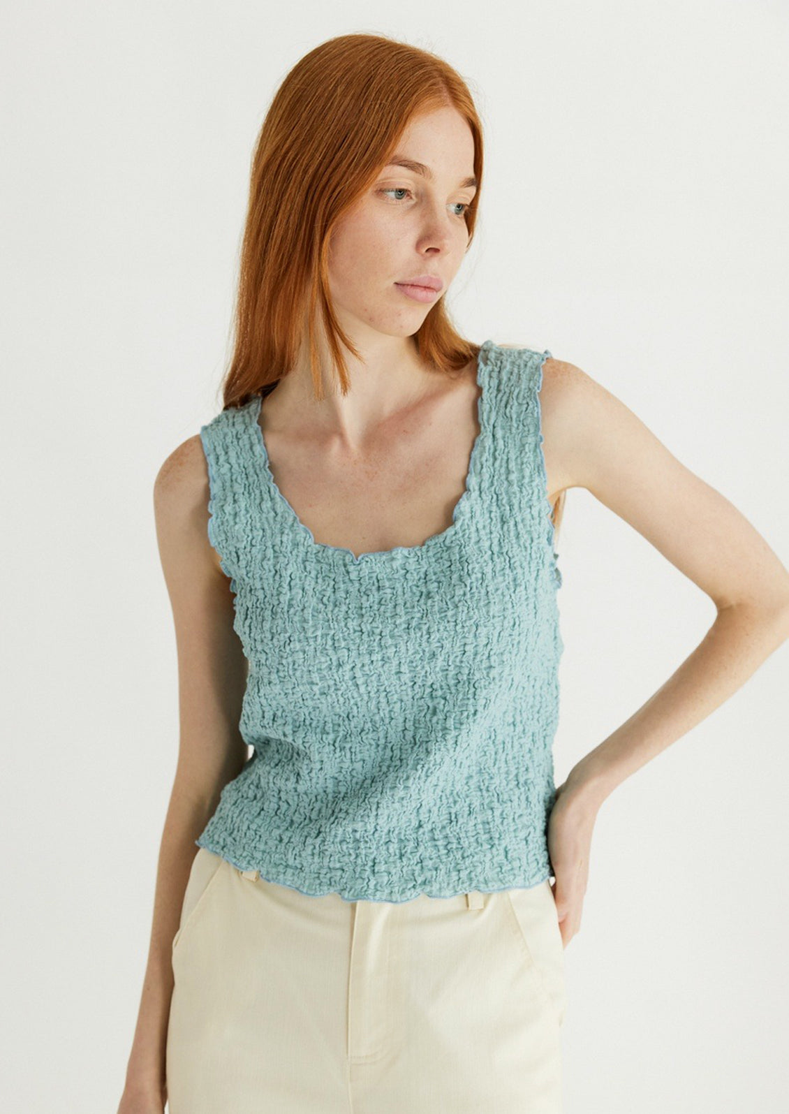 Woman wearing cyan tank top. 