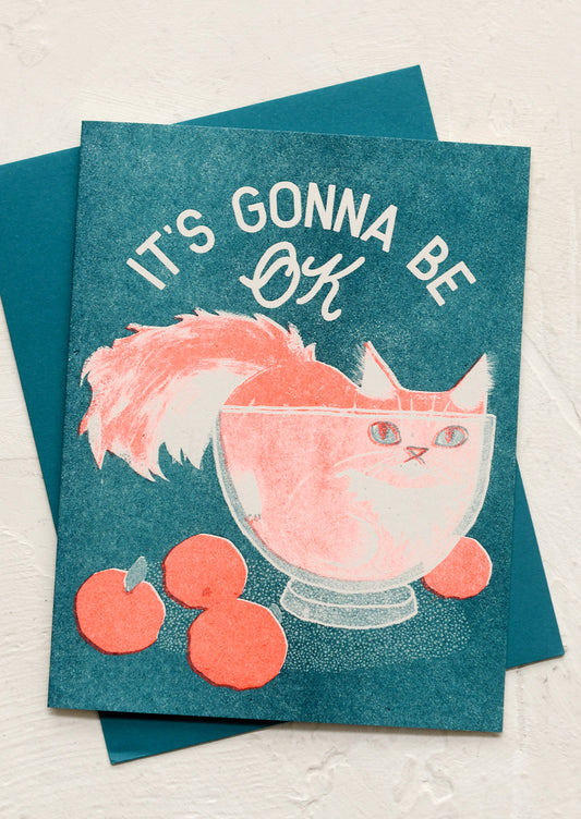 A risograph printed card with image of cat in bowl, text reads "it's gonna be ok".