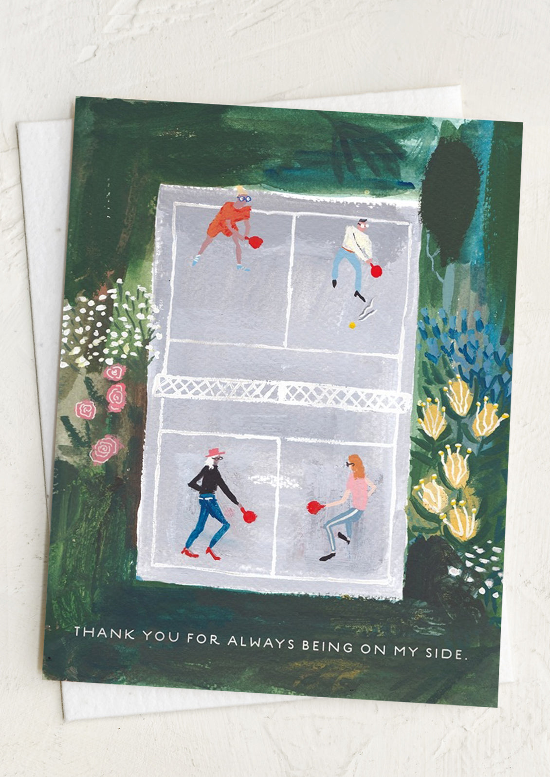 Greeting card with illustration of people playing badminton on a court, surrounded by nature, text reads "Thanks for always being on my side".