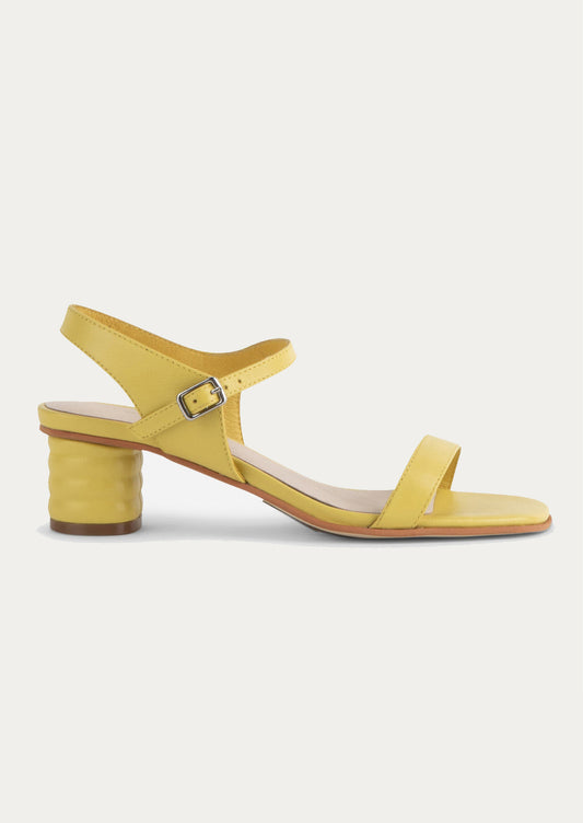 A pair of heeled leather sandals in lemon yellow.