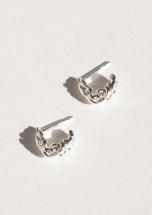 A pair of sterling silver earrings in an abstract shape.