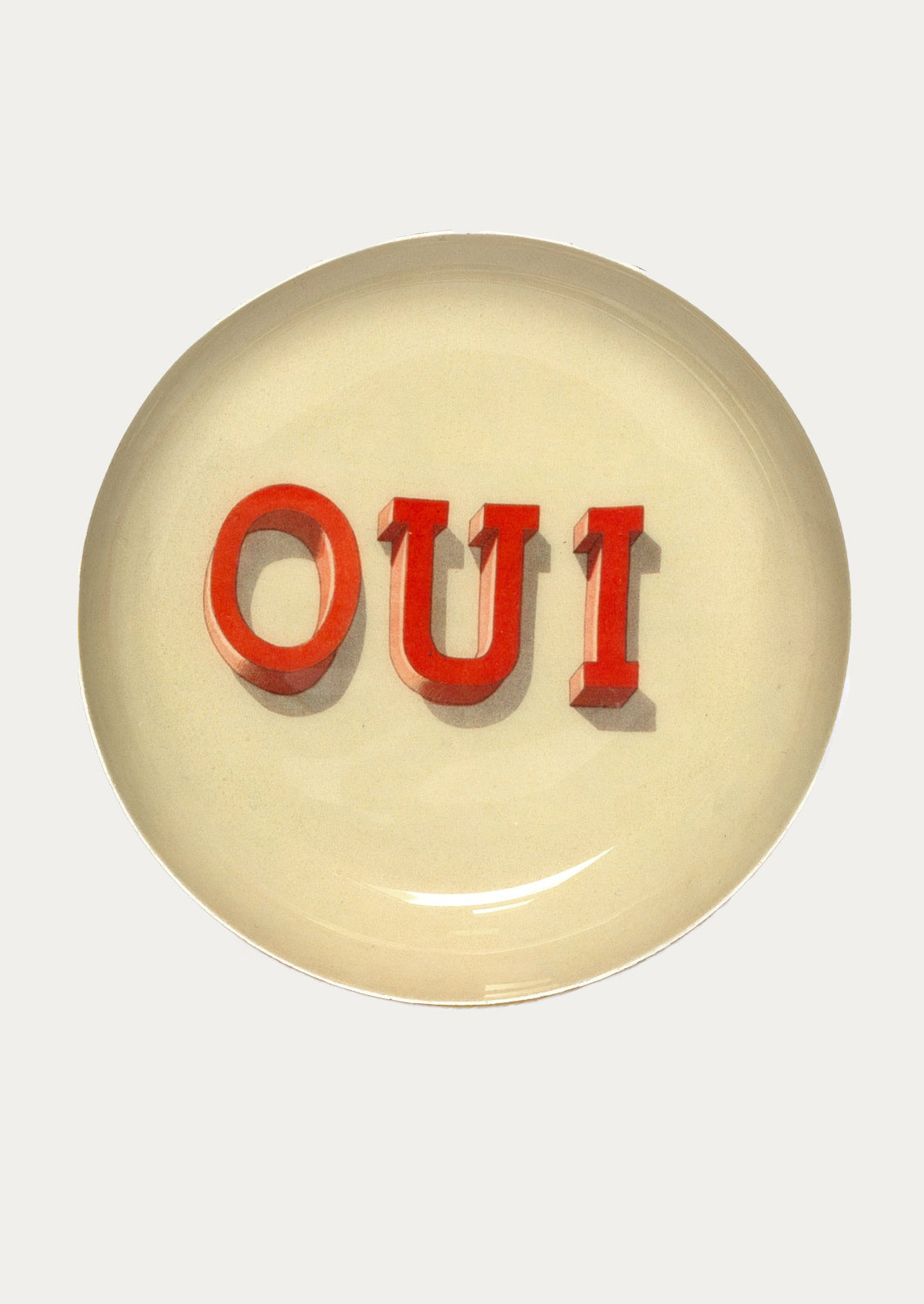 Round enamel tray with red 'OUI' text on a white background