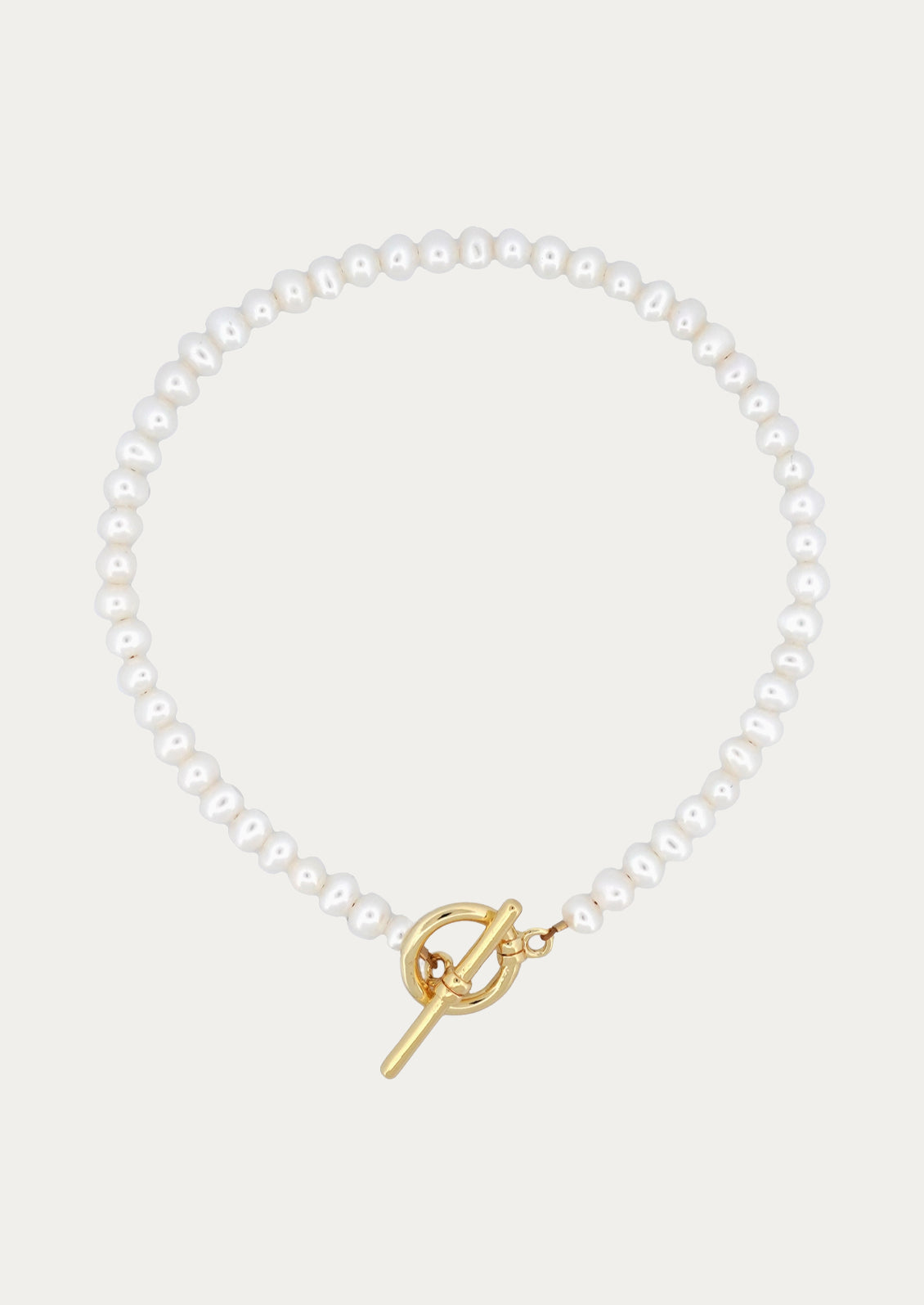 A peal bracelet with gold toggle clasp closure.