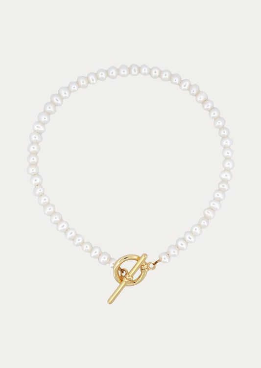 A peal bracelet with gold toggle clasp closure.