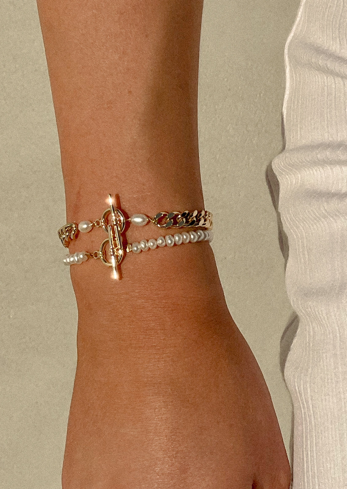A woman wearing two bracelets on her wrist.