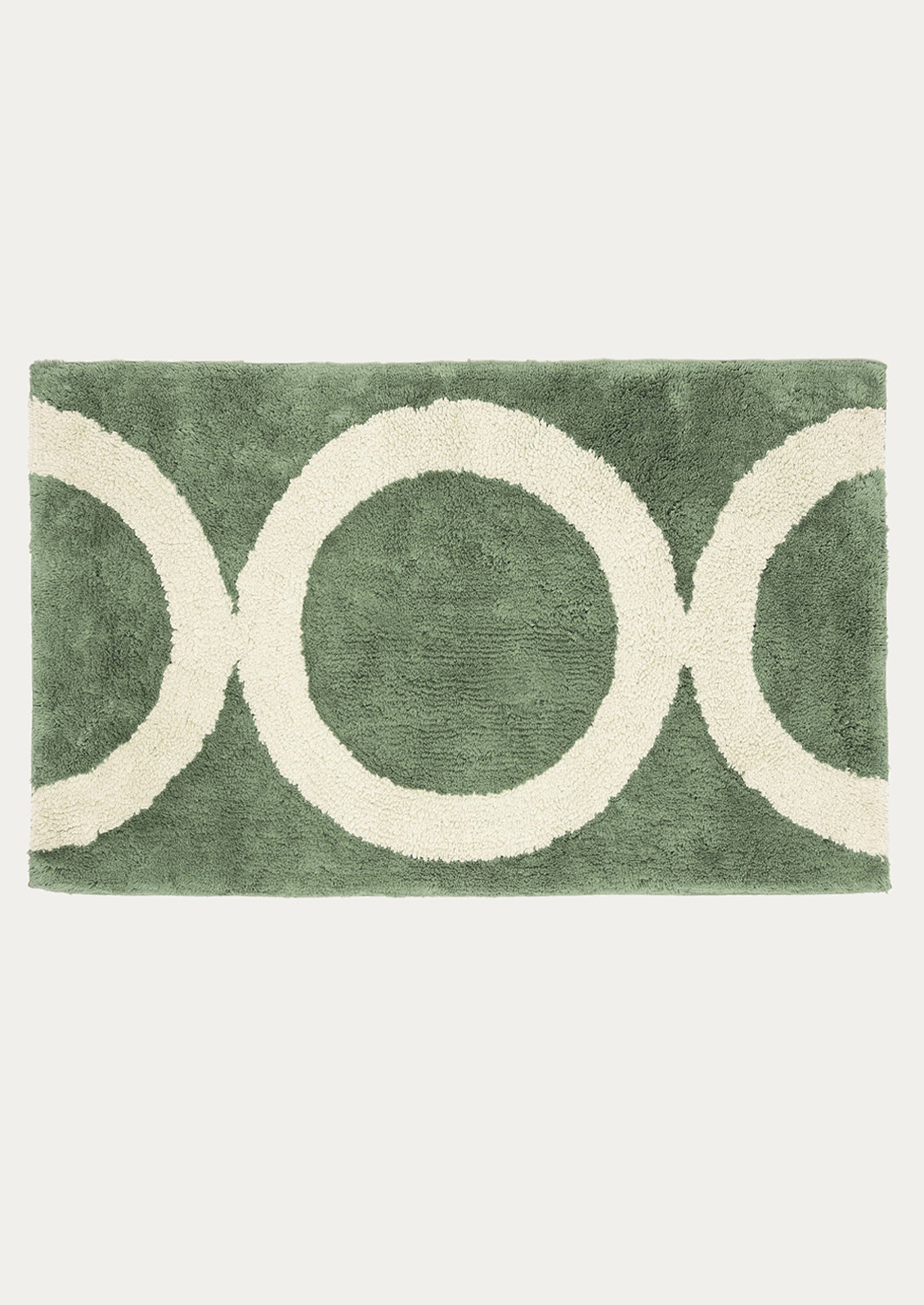 Green rug with white circular patterns on a white background