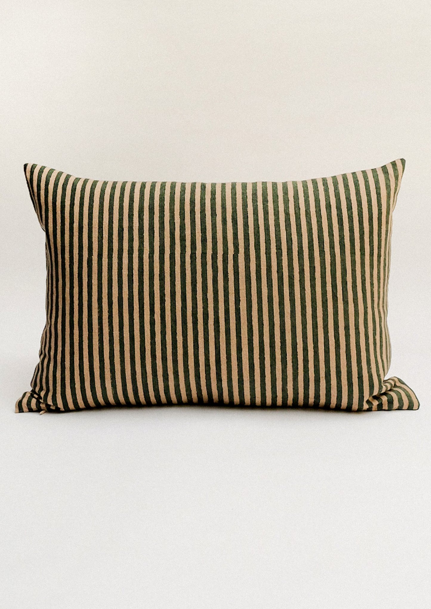 Striped pillow with green and beige pattern.