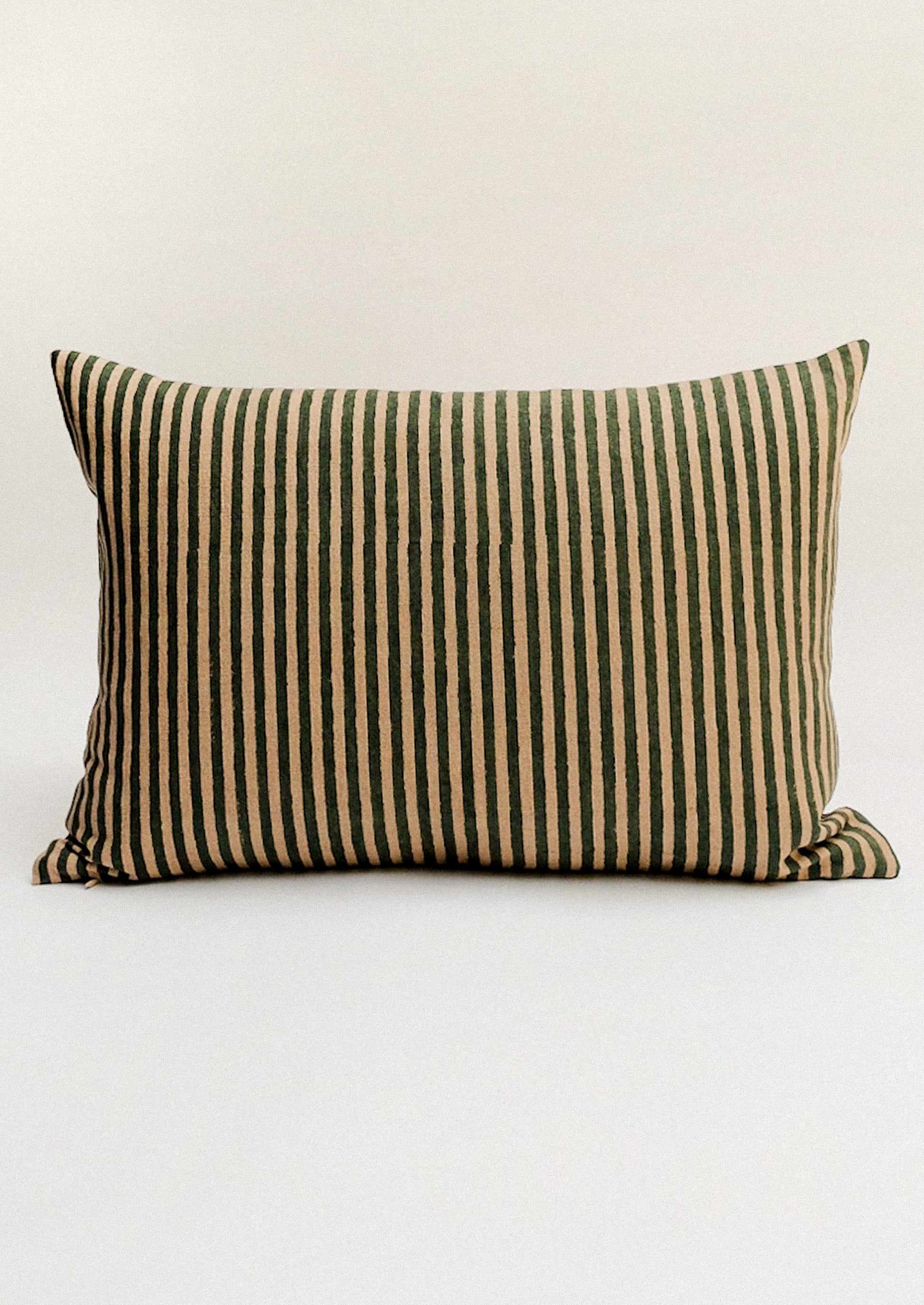 Striped pillow with green and beige pattern.