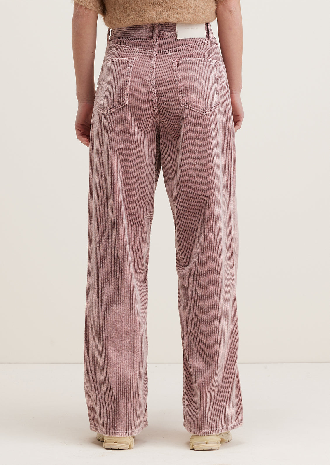 A pair of wide corduroy pants with wide leg and slouchy fit, in dusty mauve color.