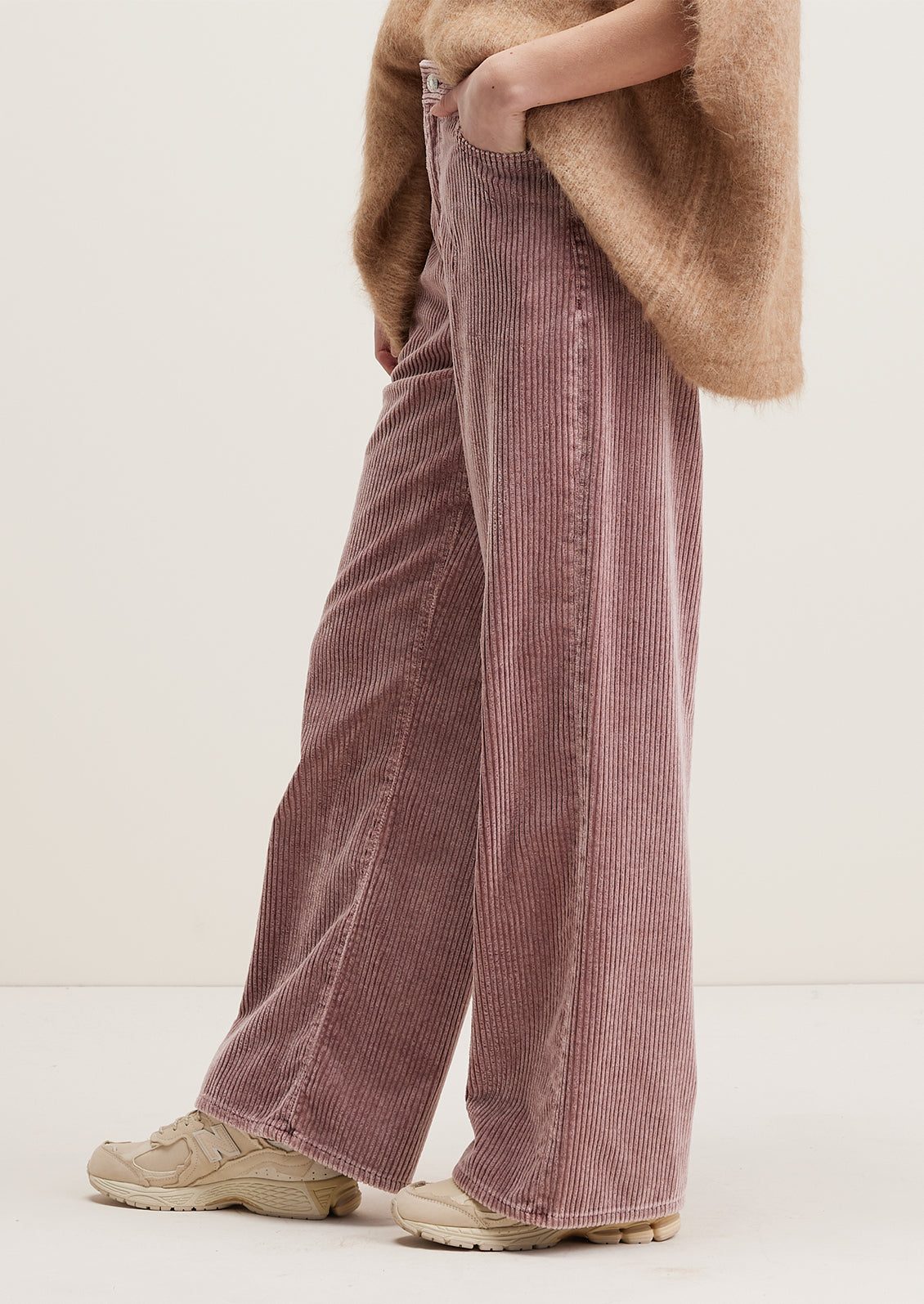 A pair of wide corduroy pants with wide leg and slouchy fit, in dusty mauve color.