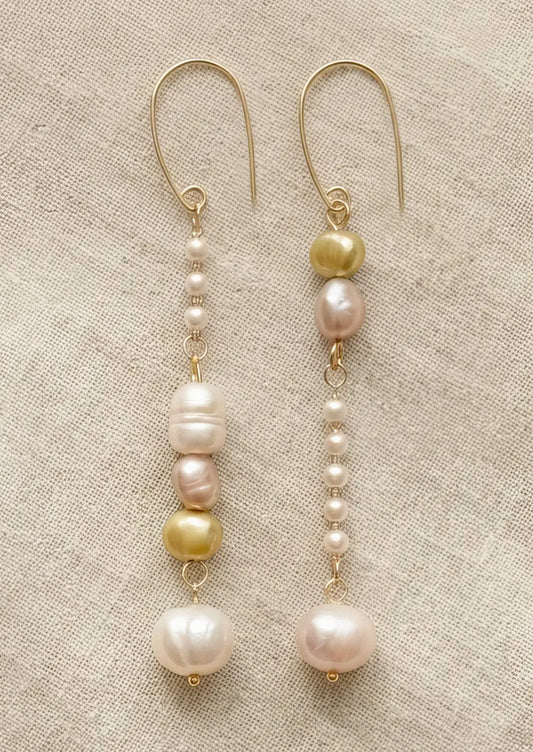 A pair of dangling earrings with freshwater pearls and faux pearls.