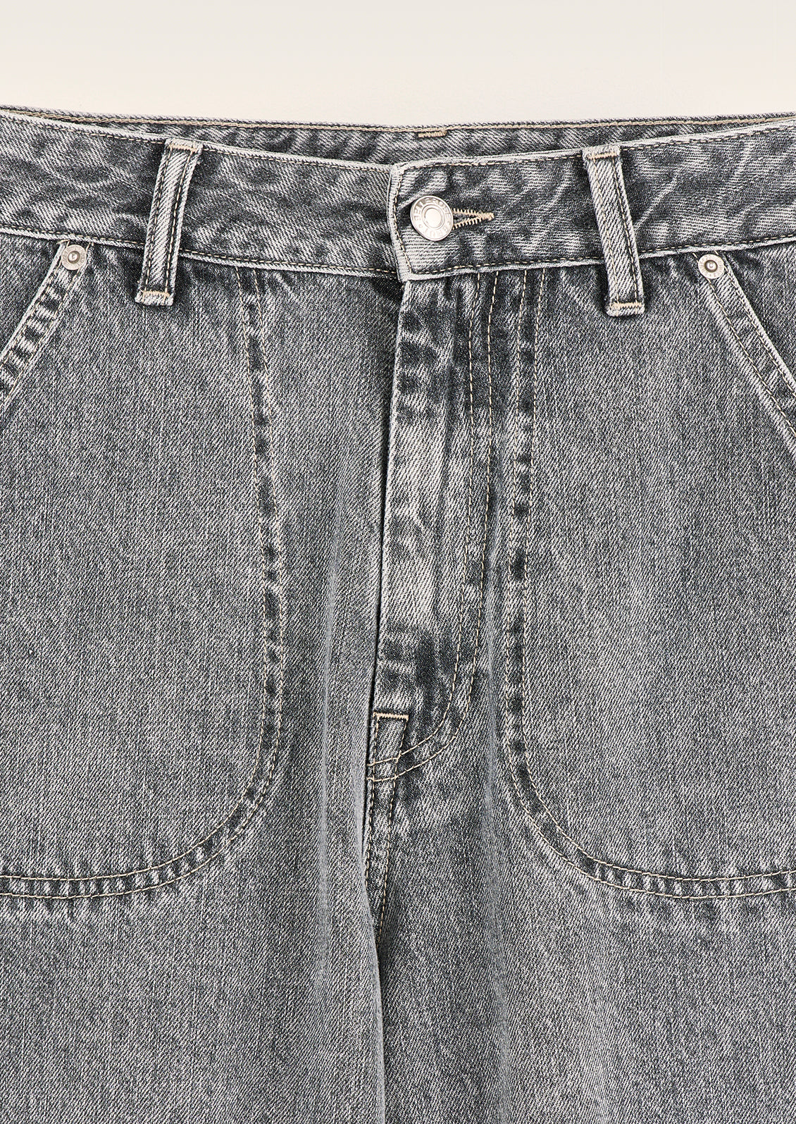 A pair of jeans in stonewashed blue-grey wash with front slant patch pockets.