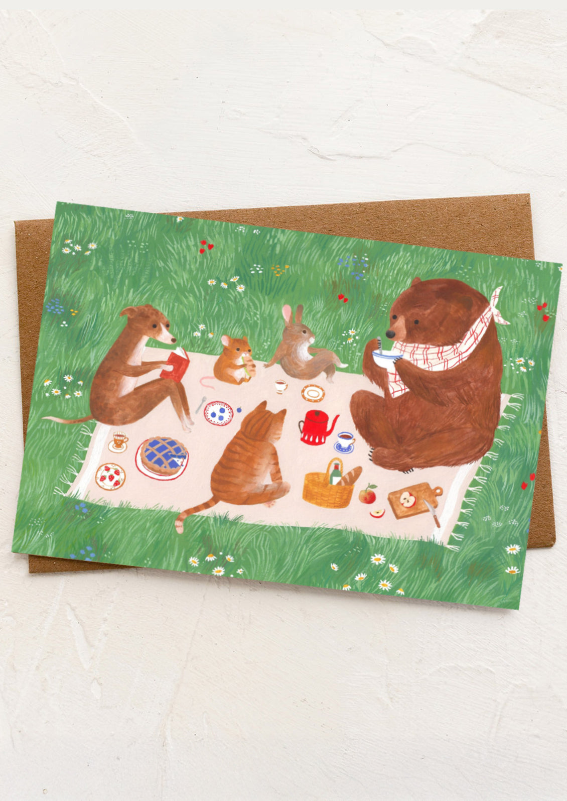 A greeting card with illustration of animals gathered around at a picnic.