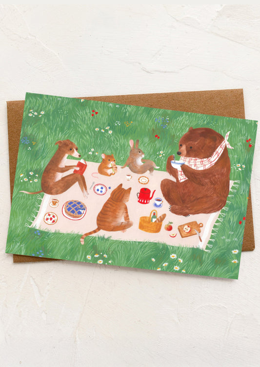A greeting card with illustration of animals gathered around at a picnic.
