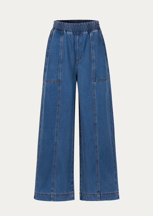 A pair of wide leg blue jeans with elasticized waistband.