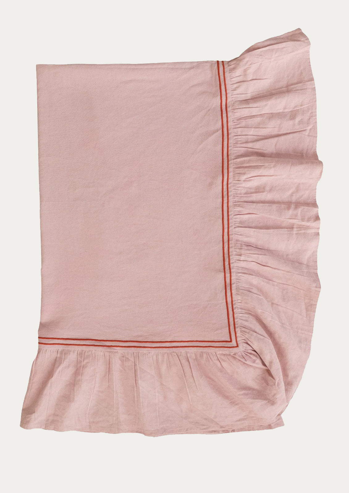 Pink ruffled tablecloth with a red trim on a white background