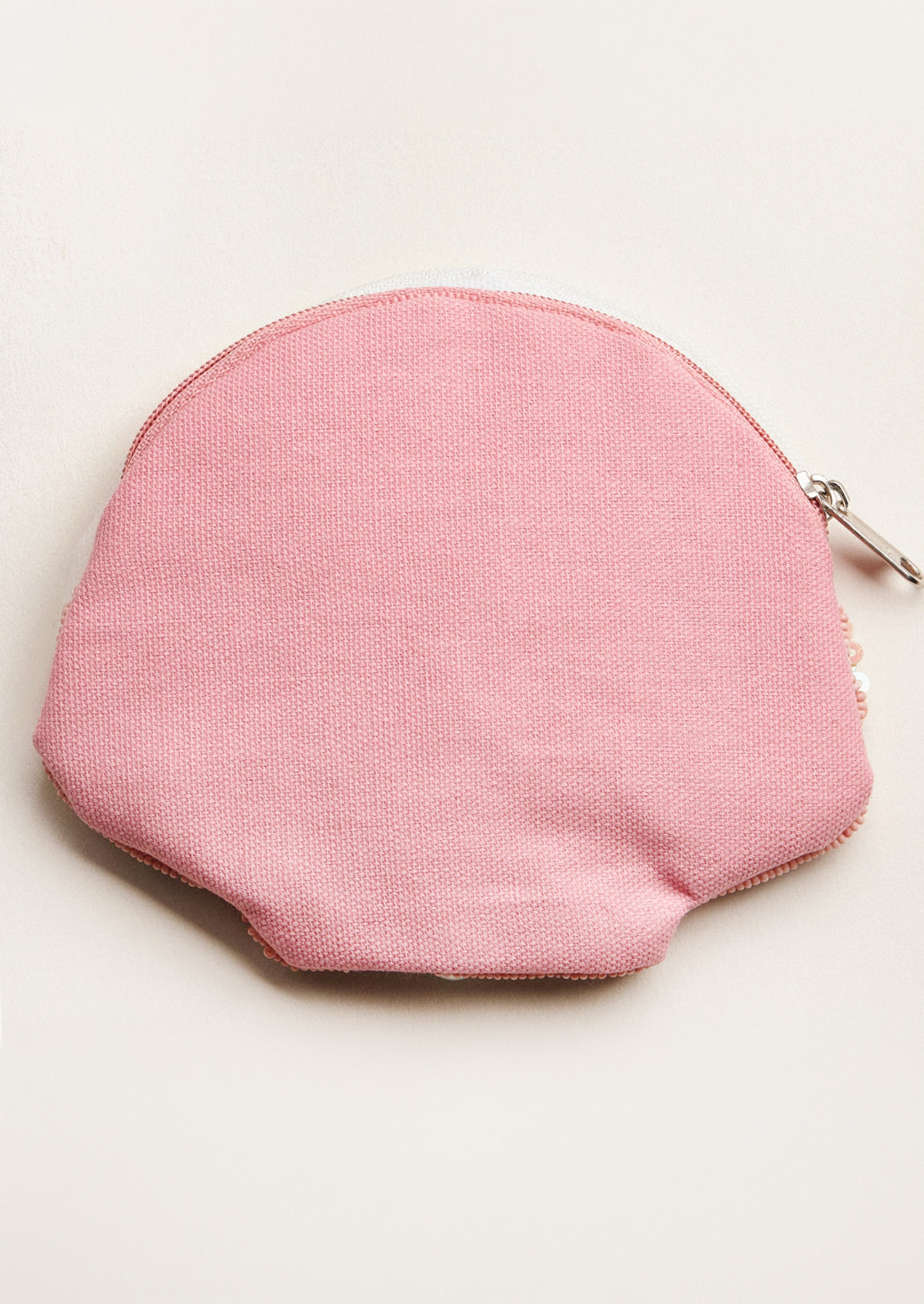 Pink coin purse on a light beige background