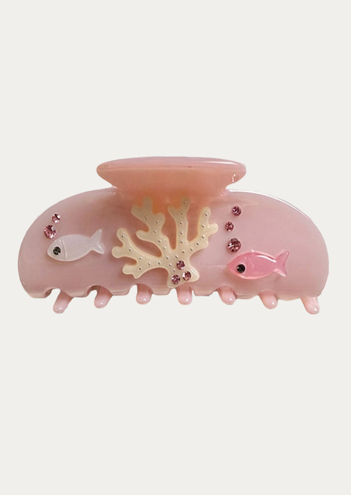 A pink hair claw with raised fish and coral applique details.