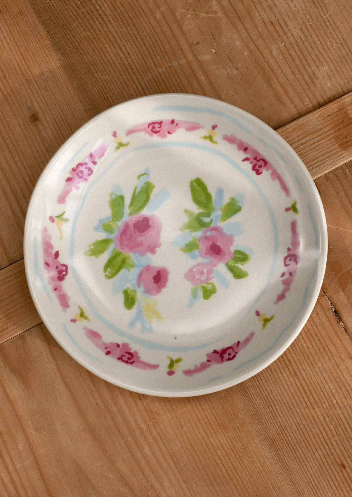 Decorative plate with floral design on a wooden surface