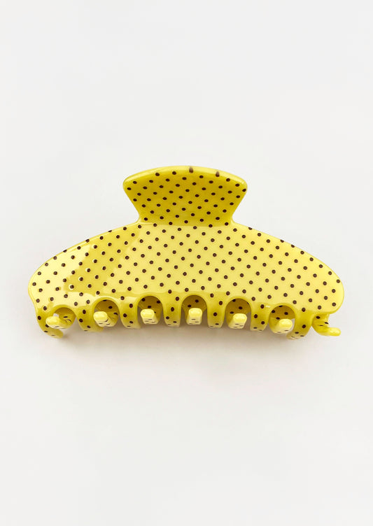 A yellow hair claw with a brown polka dot pattern.