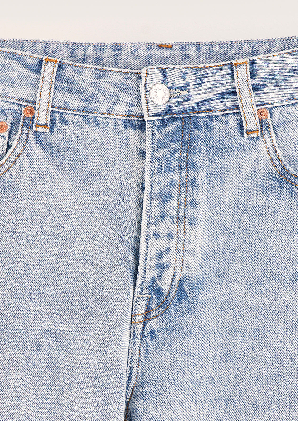 A person wearing a pair of light wash straight leg jeans.