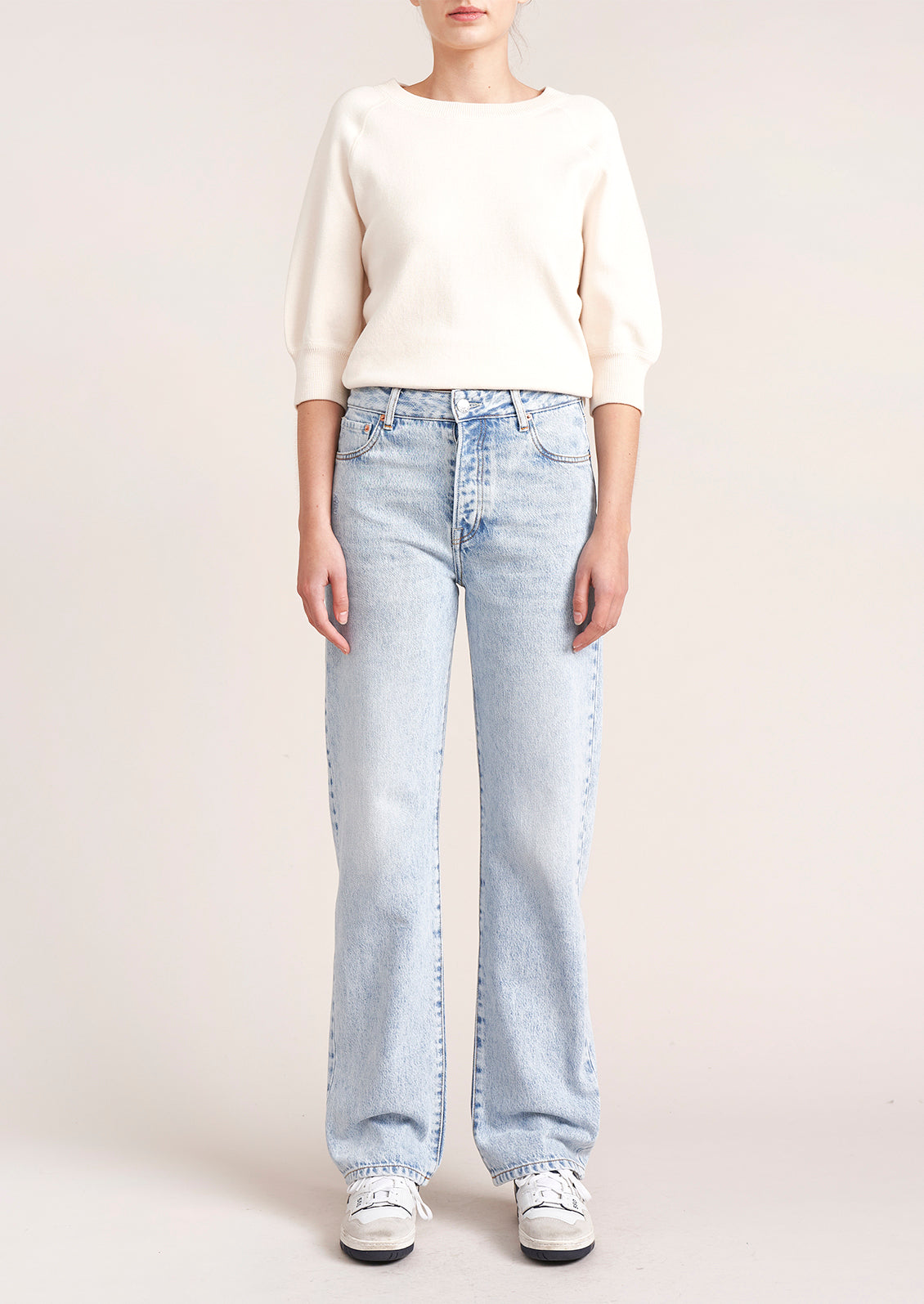 A person wearing a pair of light wash straight leg jeans.