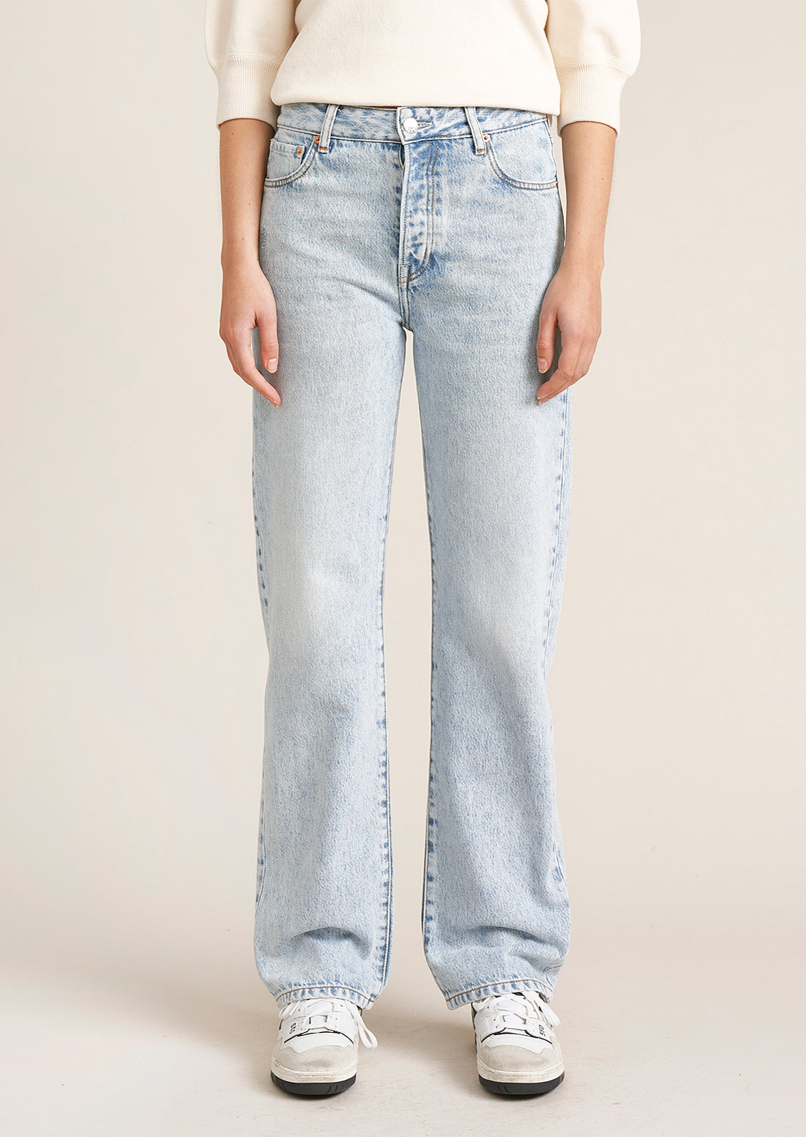 A person wearing a pair of light wash straight leg jeans.