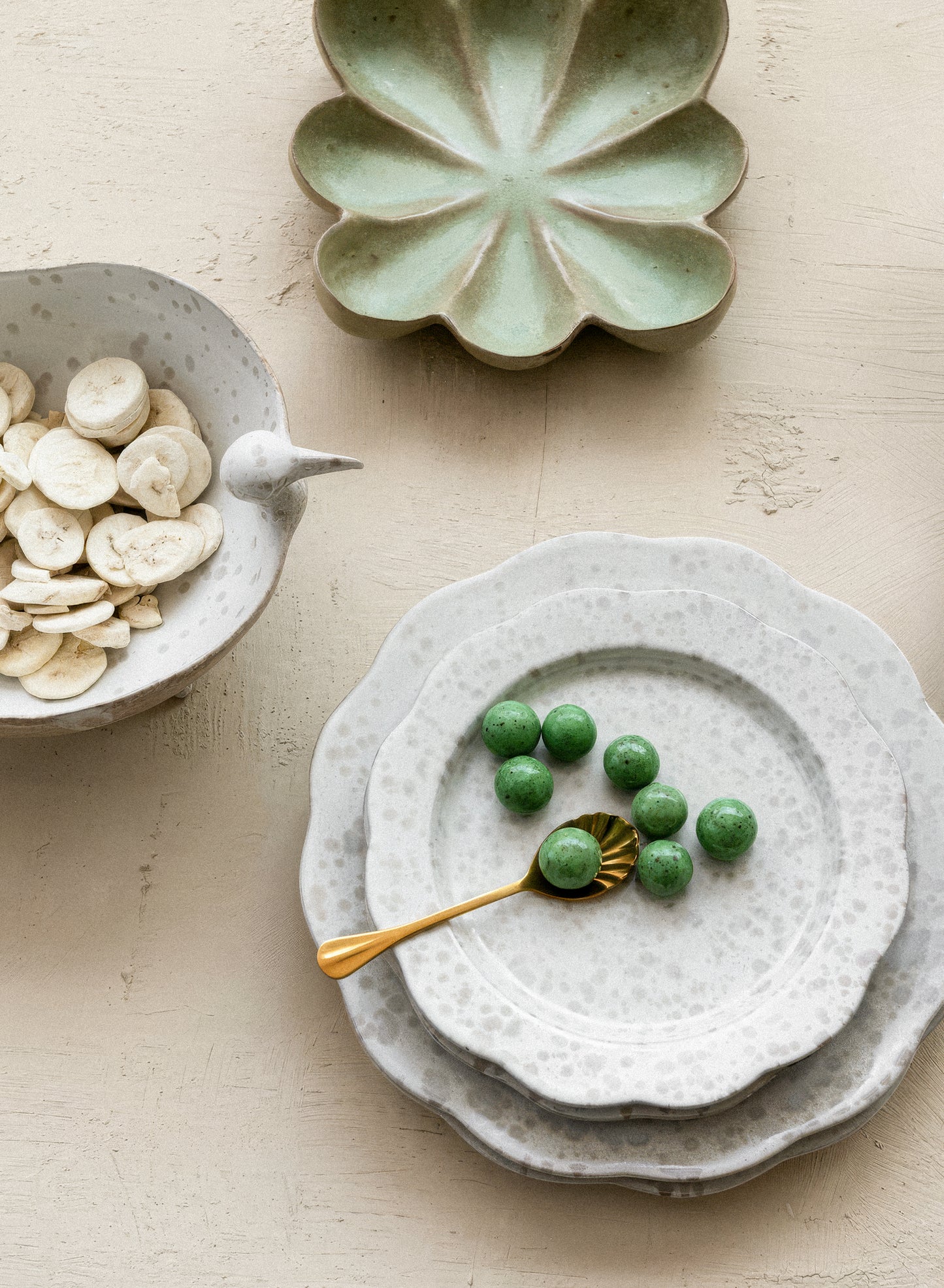 Decorative ceramic plates with green candies on a light background