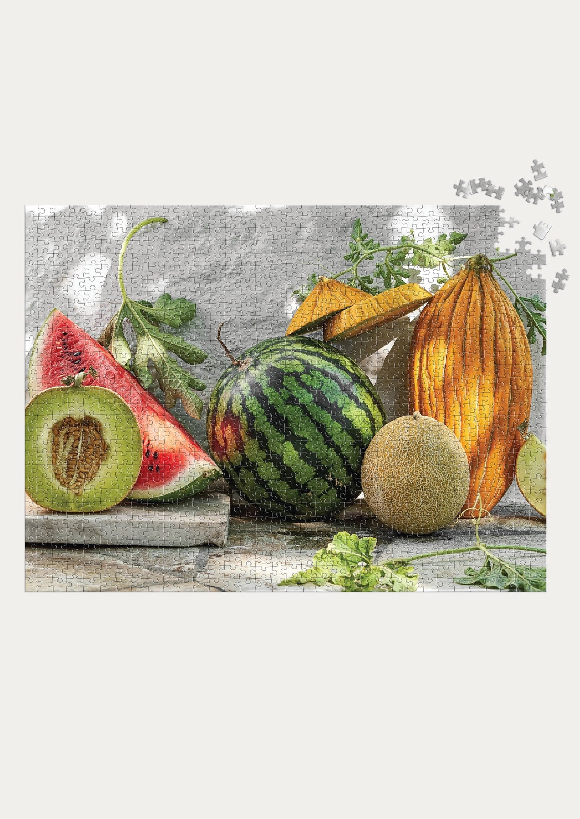 A 1000-piece fruit and vegetable still life jigsaw puzzle, featuring watermelons, cantaloupe, honeydew, and herbs on a rustic stone surface against a textured gray wall. 
