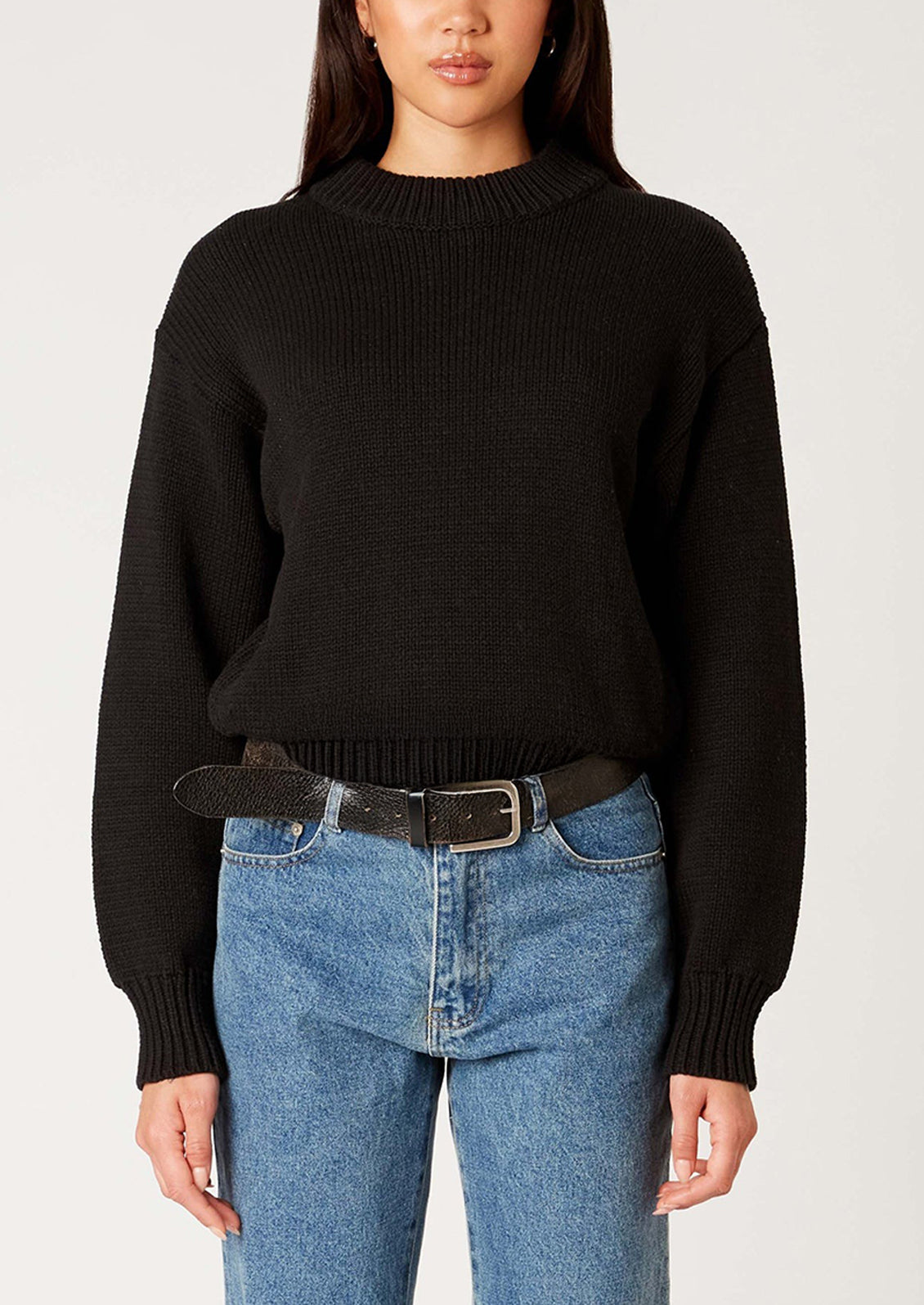 A woman wearing a crewneck sweater in navy.