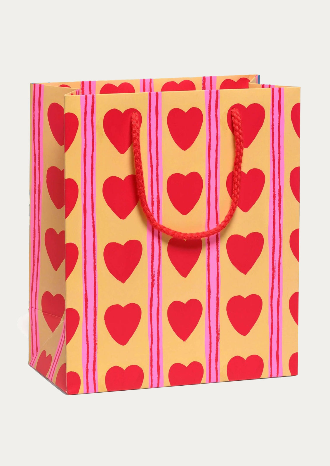 Gift bag with red heart patterns on a yellow and pink striped background