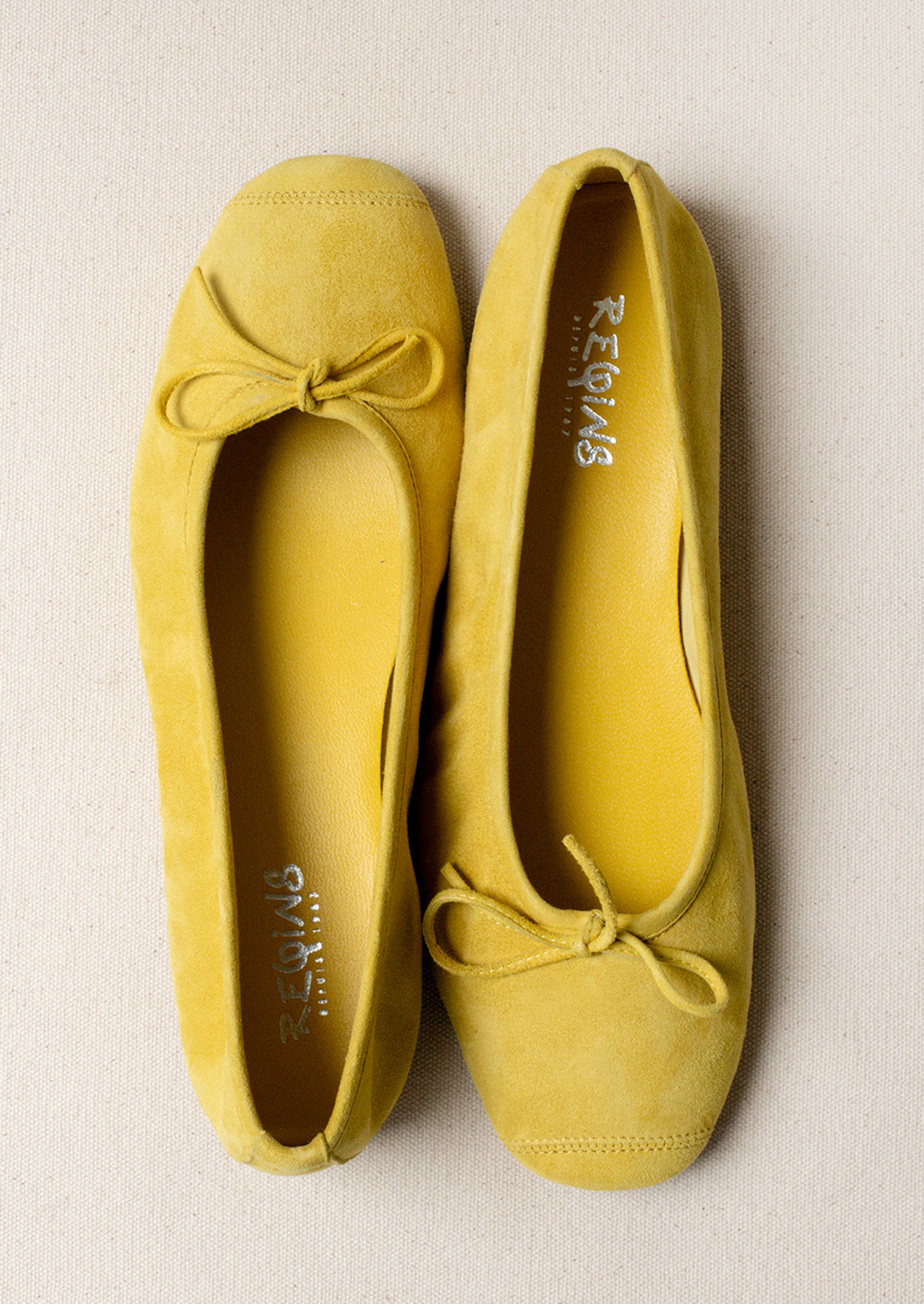 A pair of suede ballet flats in yellow.