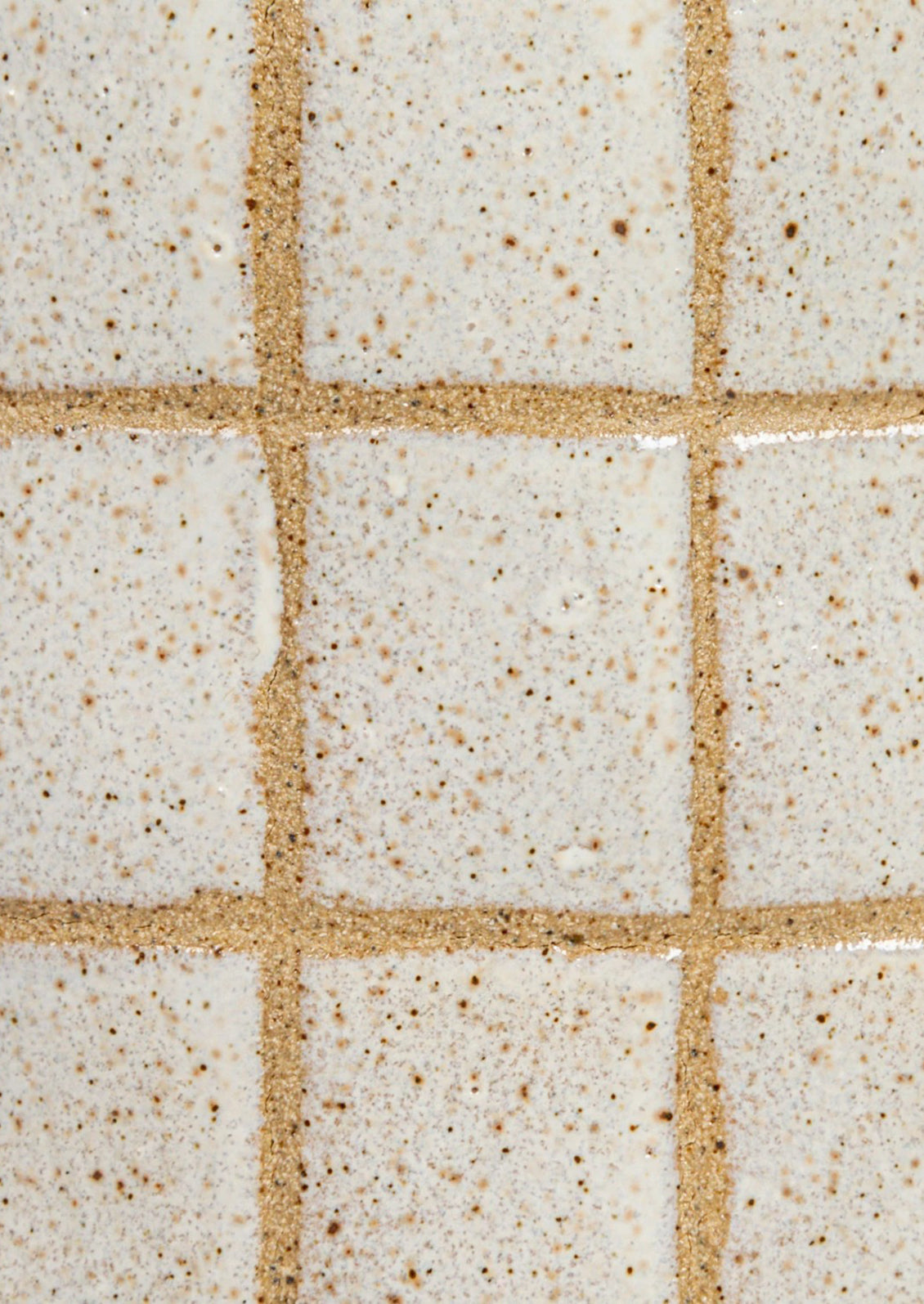 Ceramic pitcher with grid pattern on a white background