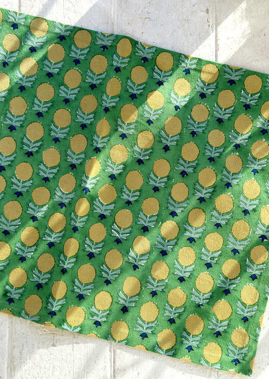 A green and yellow floral block print placemat.